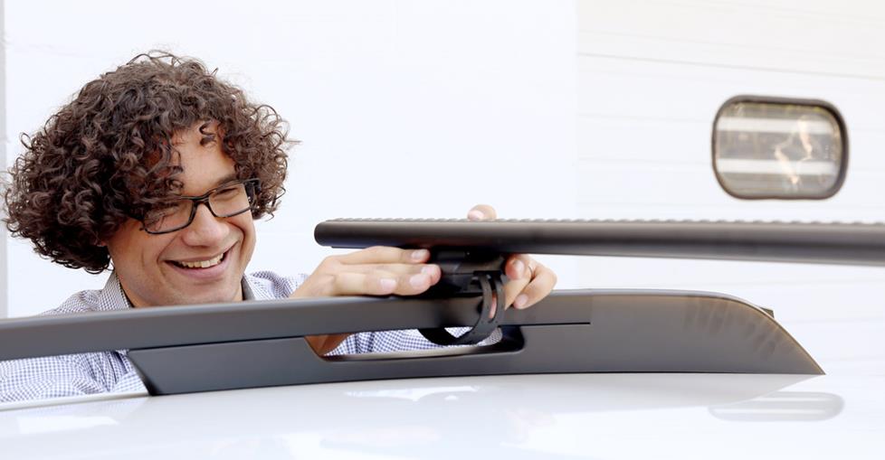 Mark secures the AeroBlade bars to the Subaru's roof rack.